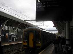 One of the railway platforms with a sign pointing the way to the platform for trams to Parkgate